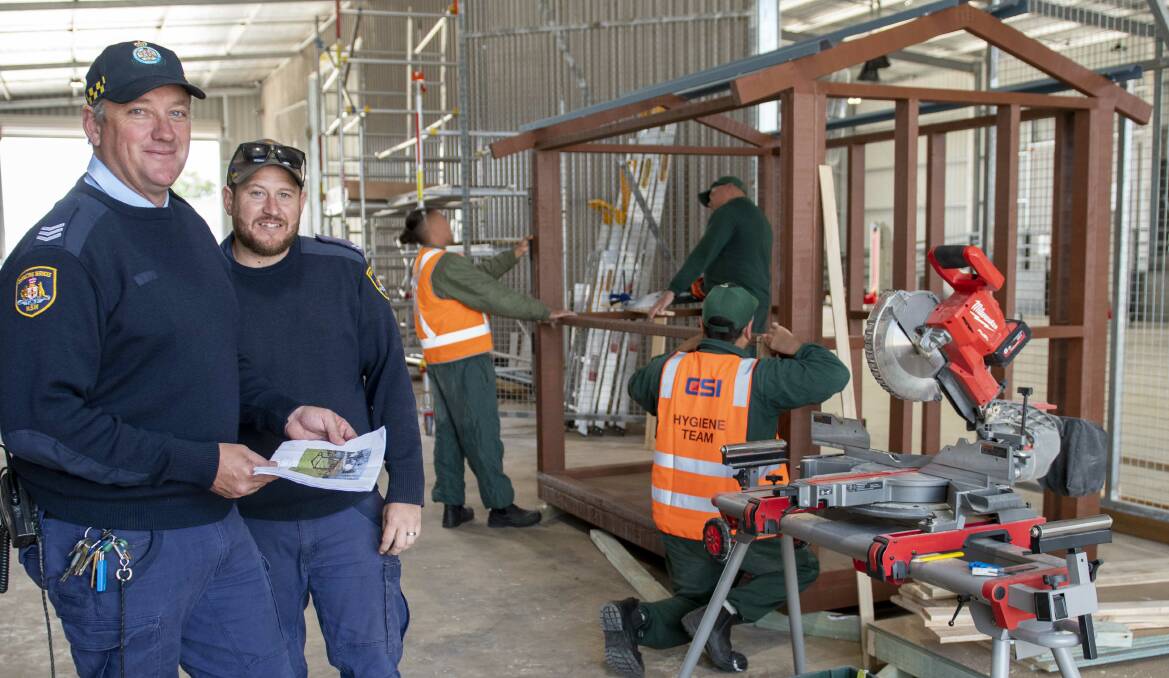 Wellington Correctional Centre inmates work on a cubby house under the supervision of Dean Matthews (L), who runs Wellingtons Modular Housing Unit. Picture by Belinda Soole