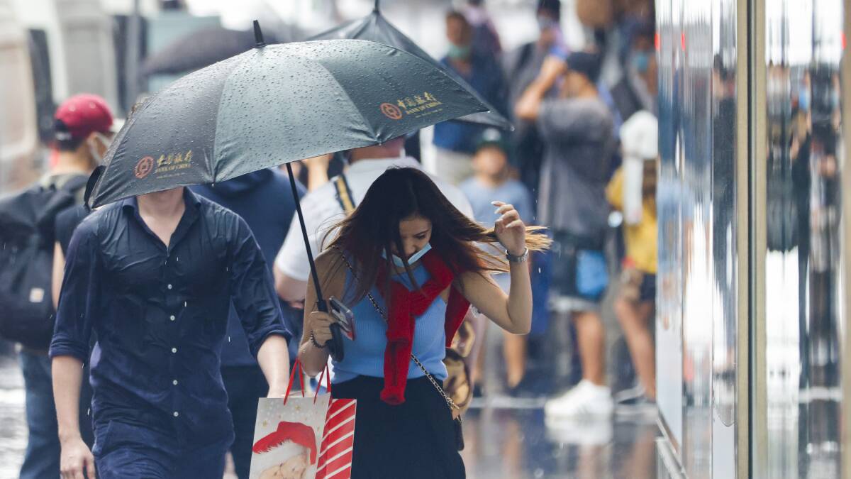 Christmas shoppers avoid the rain in Sydney on Thursday. The city is forecast for a partly cloudy Christmas with a maximum temperature of 31C - although there is a 20% chance of showers.
