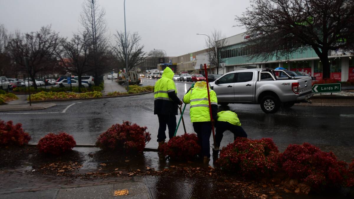 BLOCKED: Orange City Council employees were out early to clear a blocked stormwater drain on the Lords Place-Kite Street roundabout. Photo CARLA FREEDMAN