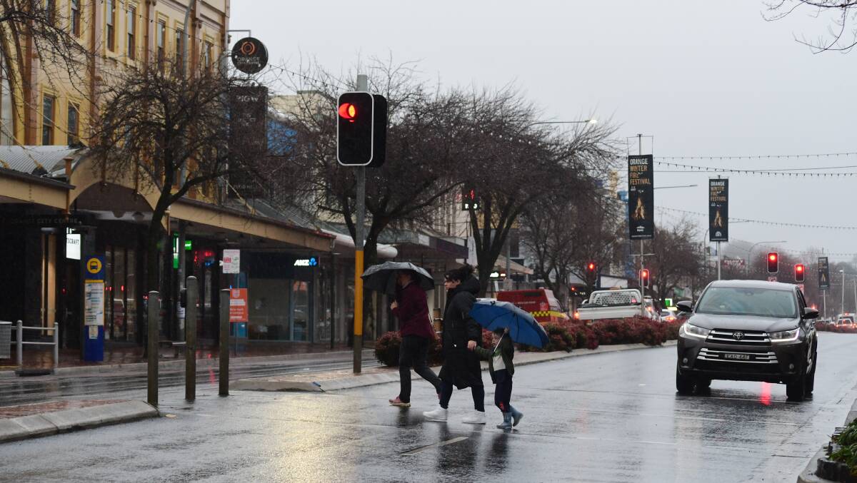BROLLIE WEATHER: Pedestrians battle the rain on Summer Street. Photo CARLA FREEDMAN