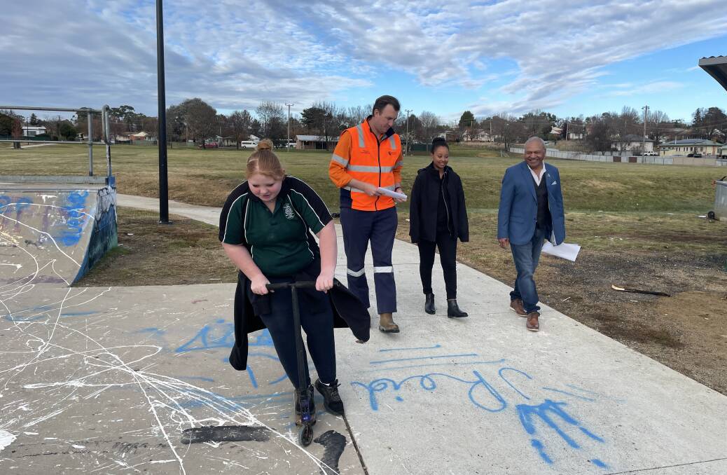 Kirra Moir scoots around the existing skatepark at Glenroi Oval while Cadia's Thomas Lethbridge, Council youth worker Hana Way and Deputy Mayor Gerald Power discuss plans to upgrade and extend the Glenroi facility. Photo KATE BOWYER