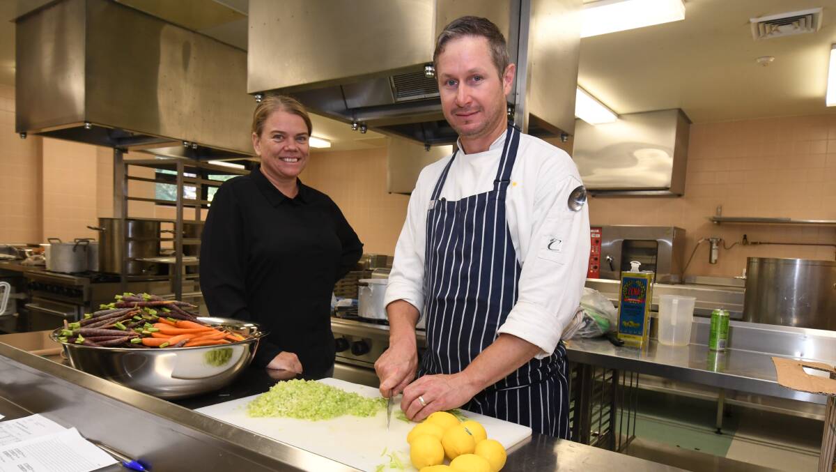 TAFE CONNECTION: Hospitality teacher Claire Tuck and commercial cookery teacher Michael Apps prepare for Saturday night's Ronald McDonald House gala ball. Photo JUDE KEOGH