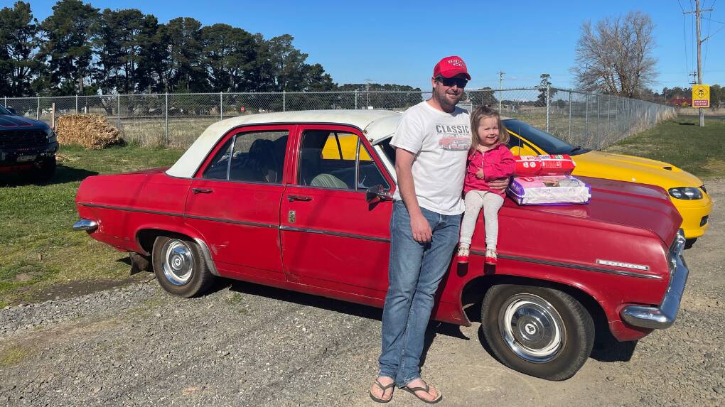 Dad Jack Pratten with his daughter Penny and some donated nappies on his Red HR Holden vehicle. Picture supplied.