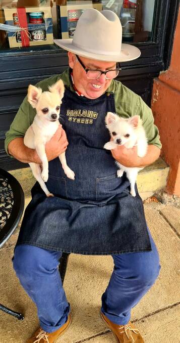 POSITIVE VIBES: Robbie with his two beloved long-haired Chihuahua's,12-year-old Sport and new addition Luckee, out the front of dad's store. Photo: SUPPLIED.