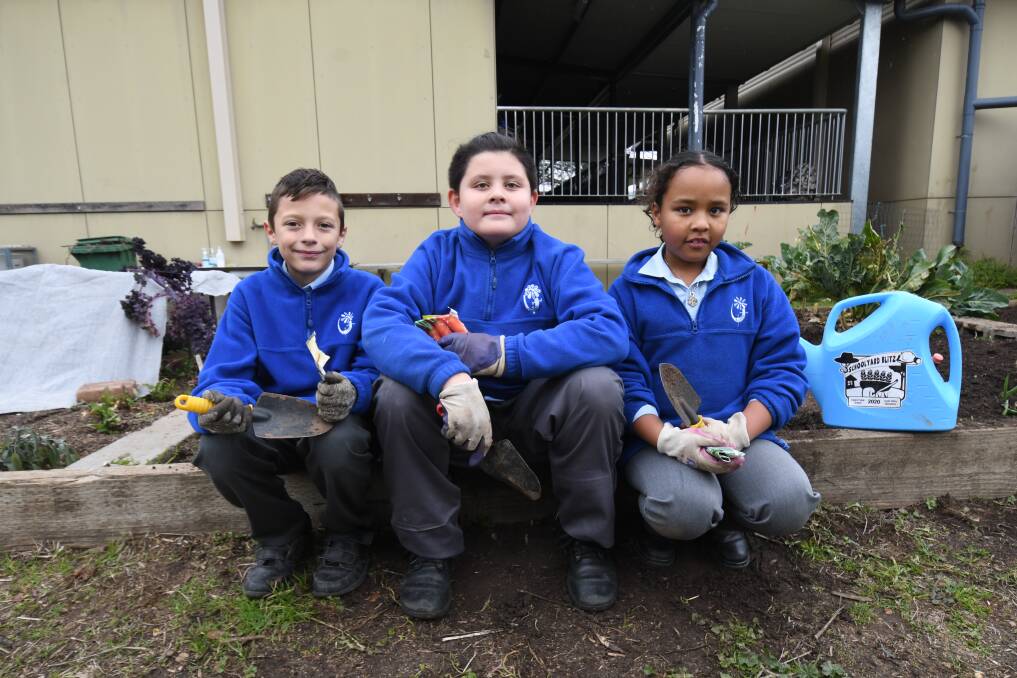 LOVING THE HUB: Students Lian Rudman, Jacob Farrell and Hannah Thuku chill out in Calare Public School's garden, which is now adjacent to a new kitchen. Photo: CARLA FREEDMAN.
