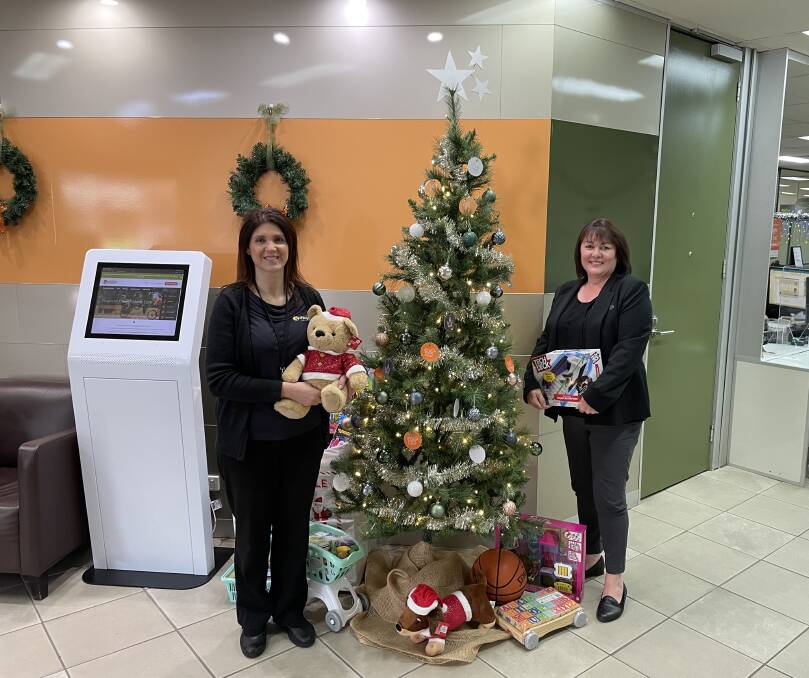PLEASE DONATE: Orange Credit Union's Sandra Paniz and Lisa Eves are feeling the Christmas spirit at the OCU branch for the Salvo's toy drive. Photo: SUPPLIED.