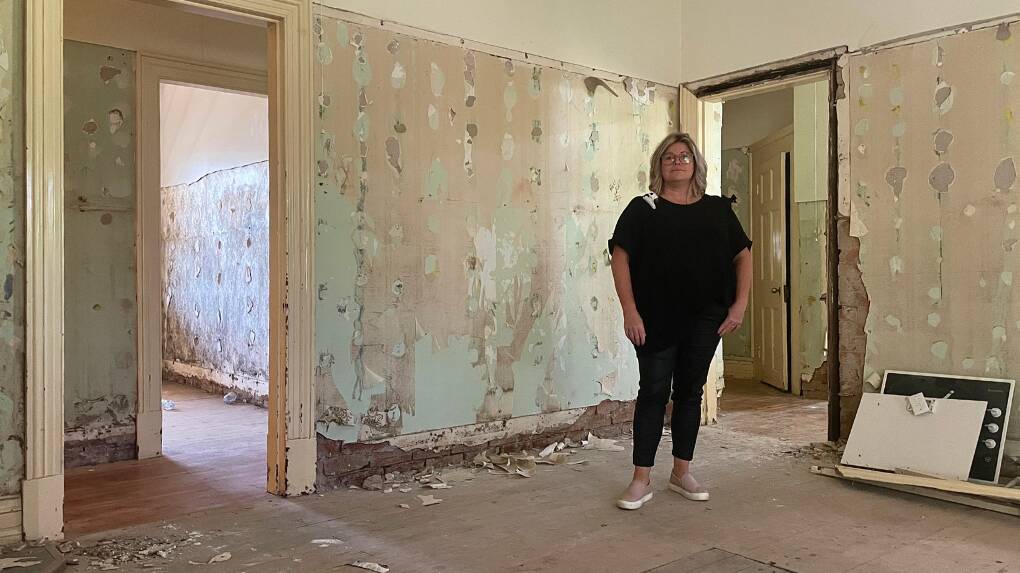 Eugowra resident and hairdresser, Amanda Mongan stands inside her gutted family home on Nanima Street more than 11 months since the flood. Picture by Emily Gobourg.
