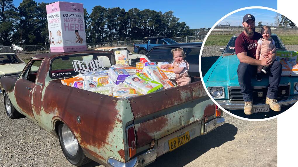 Isla Garlick sits in a ute-tray-full of donated nappies, with her and dad Darcy Garlick proudly part of The Nappy Collective movement on the bonnet of a teal Kingswood. Pictures supplied.