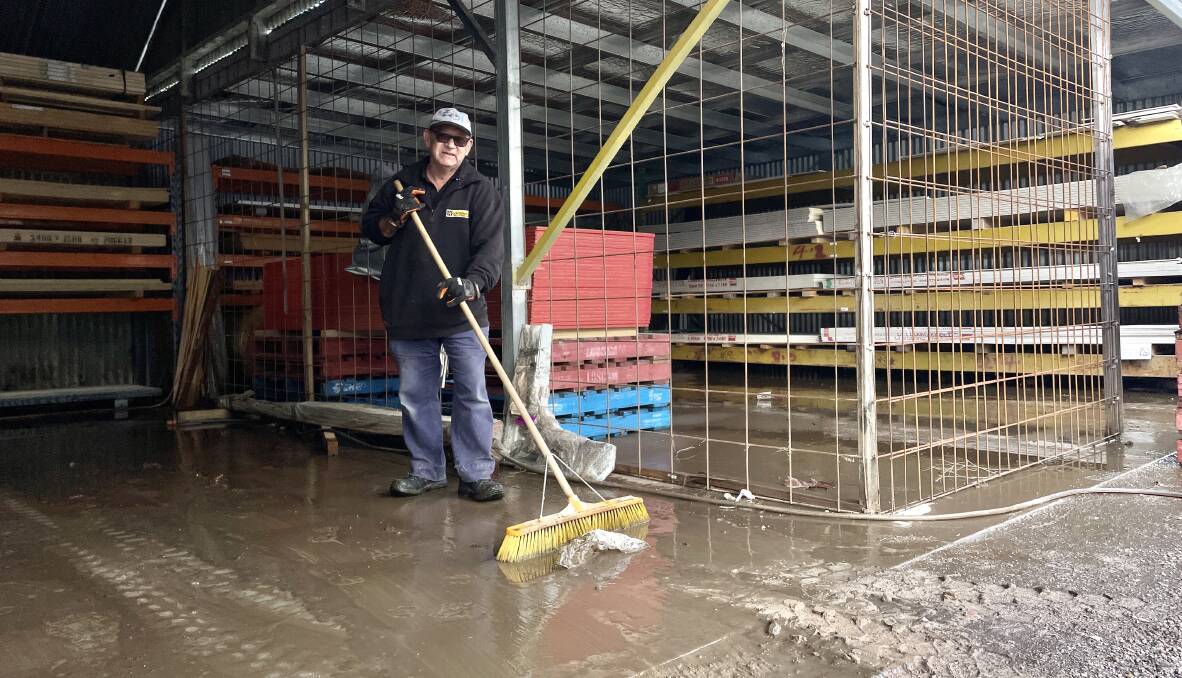 Molong H Hardware's Michael Frew clearing the aftermath of floodwaters early on Tuesday morning. Picture by Emily Gobourg.