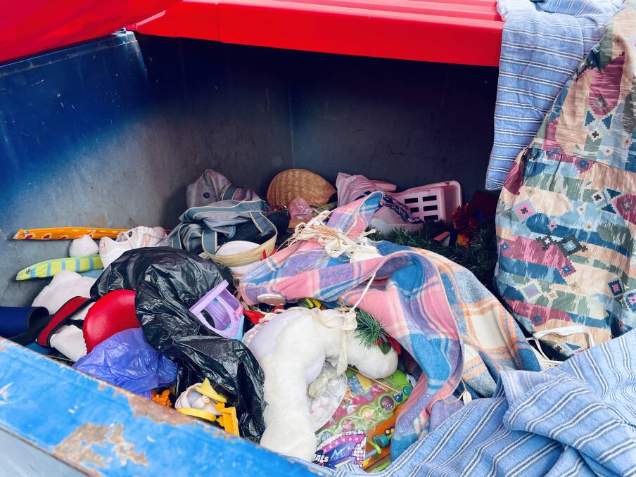 WHAT A LOAD OF RUBBISH: Mary Mulhall couldn't understand the motive behind damaging the charity shop's property, revealing the waste contents of the busted skip bin. Photo: EMILY GOBOURG.