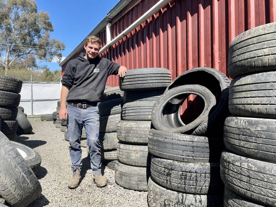 Second-year apprentice at Molong Tyre & Mechanical, Jake Murray stands alongside dozens of pothole-busted tyres. Picture by Emily Gobourg.