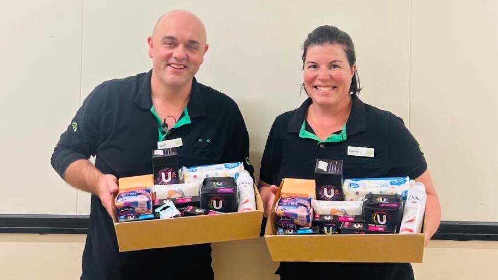 Woolworths North Orange manager with the store's bakery department manager, Scott Clayton and Davina Wright hold female hygiene hampers to donate to Orange Emus for the new women's change rooms. Picture supplied.