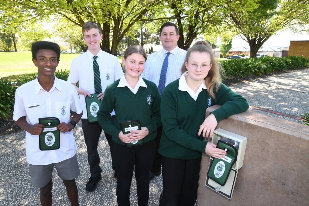 Canobolas Rural Technology High School students, Samuel Gross, Milton Knight, Mia Warren, with principal Brett Blaker and student, Erin Anderson, unlock their phone pouches after day one of all-new Mobile Phone Policy, October 9. Picture by Jude Keogh.