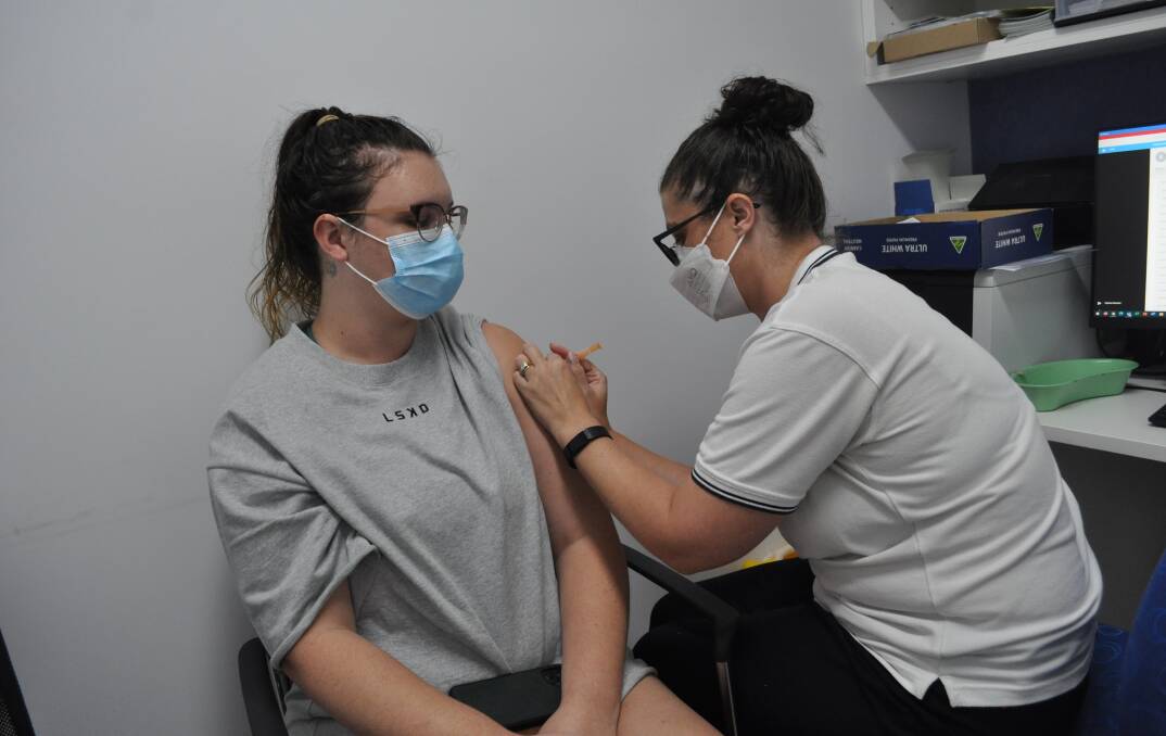 HIGH-DEMAND: Hogans Pharmacy's Emily Wilkie giving Bronte Featon a booster jab on Tuesday; shots which are currently in high-demand almost everywhere across the state. Photo: NICK MCGRATH.