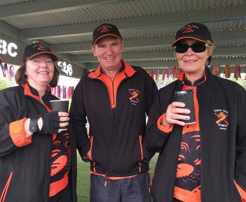 PADDLERS: Colour City Dragons members Jasmine Vidler, president John Moss and June Bennett enjoy a coffee during a day of dragon boat racing at the Parkes fourth anniversary regatta. Photo: SUPPLIED.