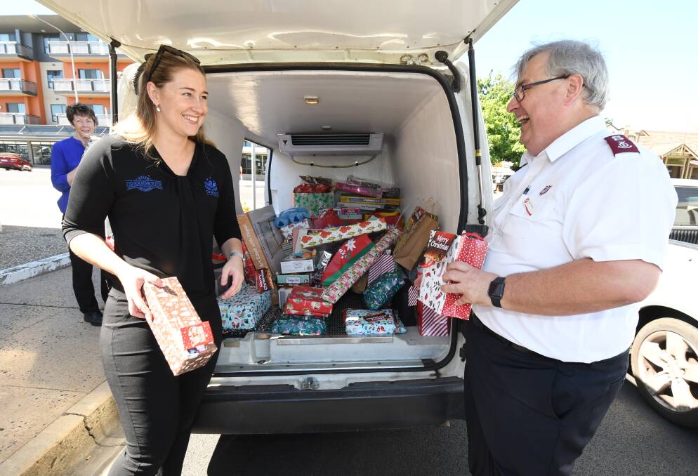 AT CAPACITY: Marketing and communications manager for the club, Ellie Eveleigh, helps Major Colin Young unload the ex-servies' wave of generosity. Photo: JUDE KEOGH.