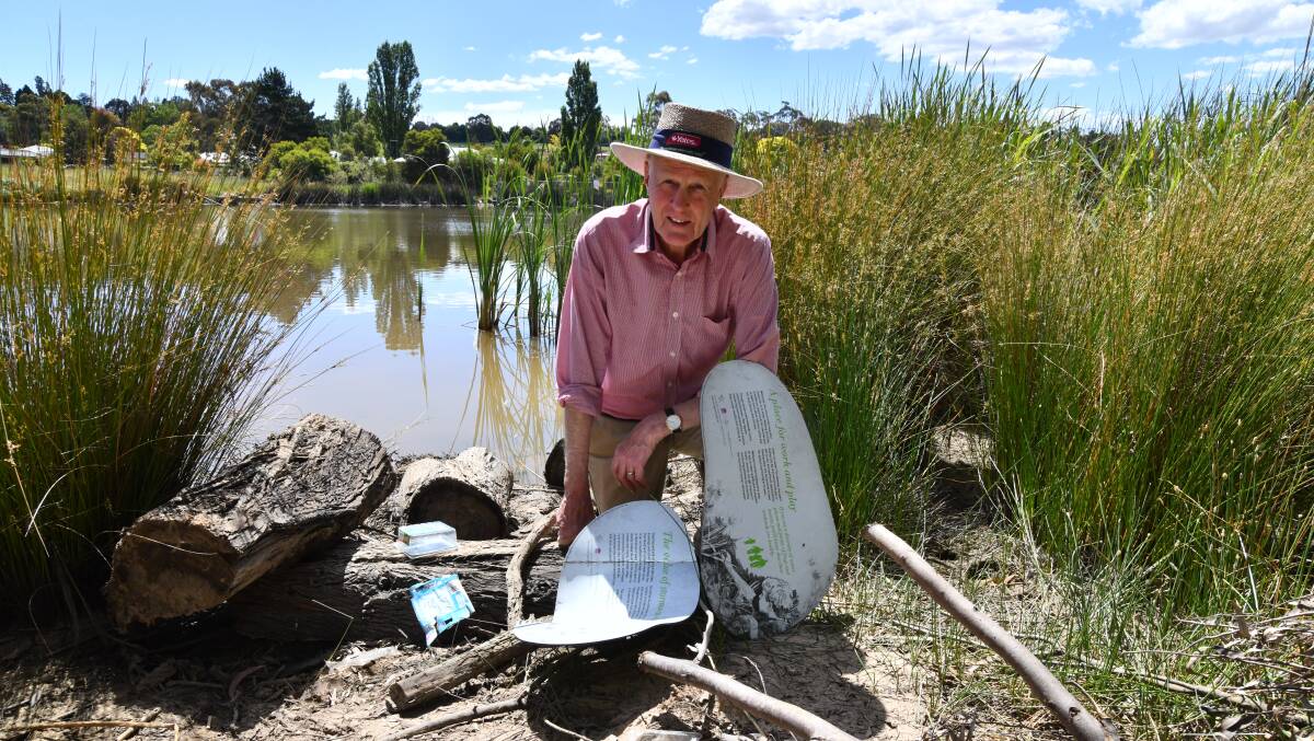 Chairman of the Ploughmans Wetlands Care Group Neil Jones with broken signs and litter at the Ploughmans Wetlands in Orange. Picture by Carla Freedman. 