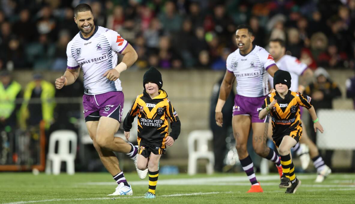 MAIN EVENT: Melbourne Storm superstars Jesse Bromwich and Josh Addo-Carr run onto Carrington Park in 2019 with two Oberon Tigers juniors. Photo: PHIL BLATCH