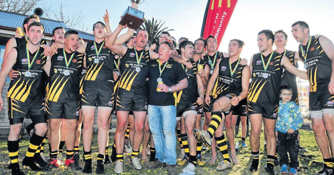 LIFT THE TROPHY: The Orange Tigers celebrate winning back-to-back Central West AFL flags in 2014. Photo: JUDE KEOGH 