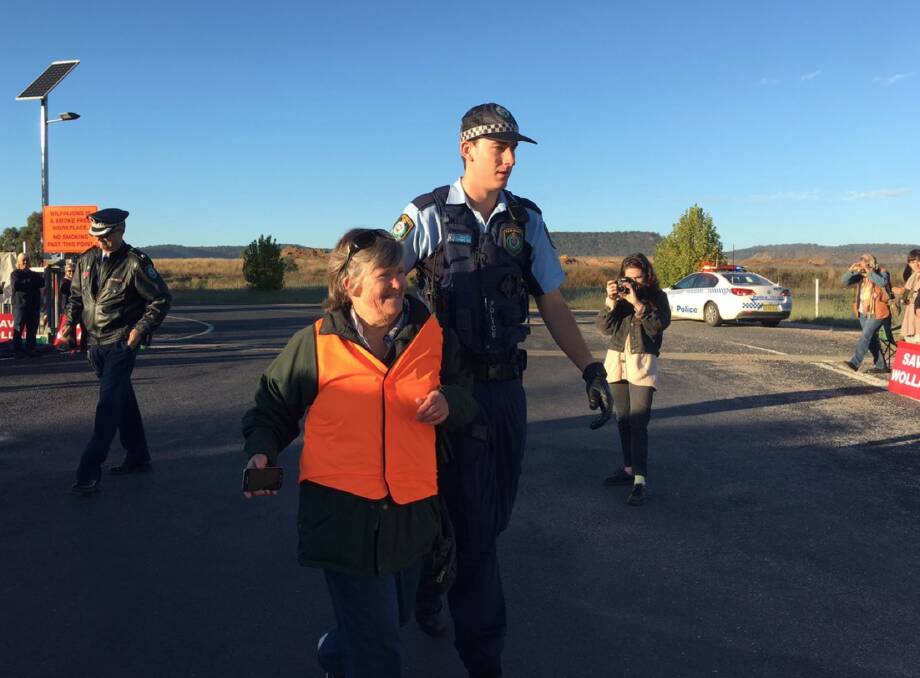 ARRESTED: Bev Smiles being escorted by police following a protest against the expansion of the Wilpinjong coal mine near Mudgee. Photo: JEMIMA GARRETT 041917protest3