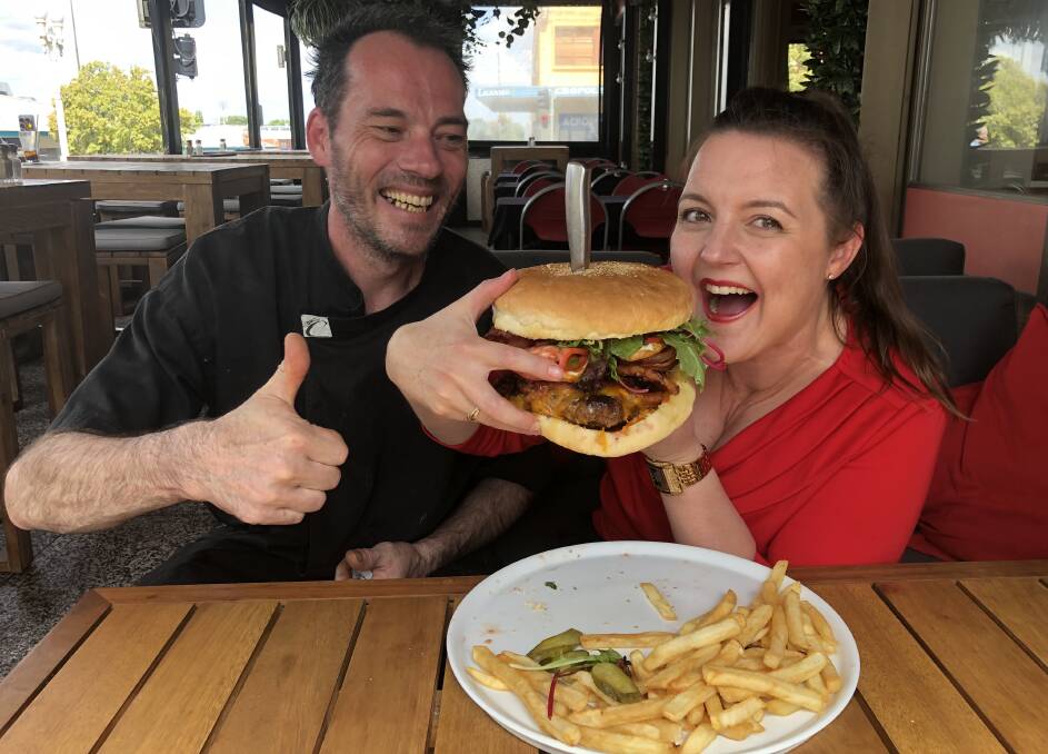 A REAL MOUTHFUL: Fiona Miller, pictured with chef Michael Sterns, trying her luck with the Bathurst Burger Challenge.