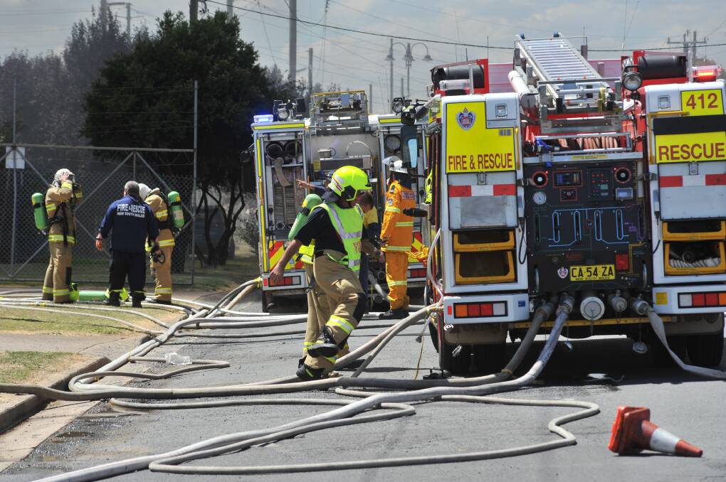 TURN ON, TURN OFF: Firefighters battling a blaze which was started behind JG Auto Sales and threatened the RSPCA animal shelter on William Street. Photo: JUDE KEOGH