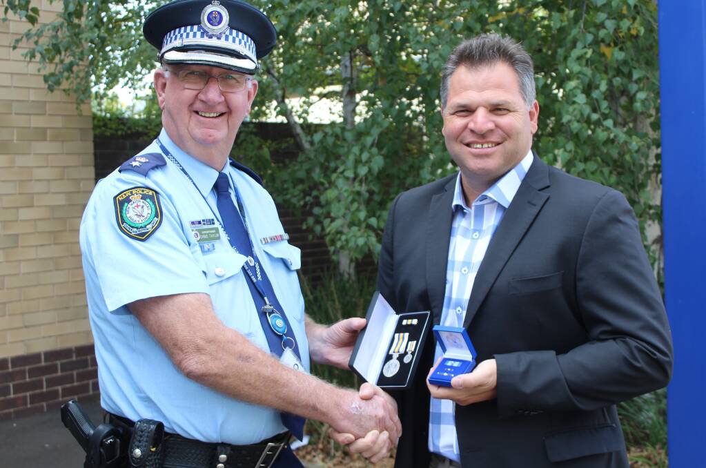 ACKNOWLEDGED: Member for Orange Phil Donato receiving his awards from Central West Police District Commander Superintendent Chris Taylor. Photo: SUPPLIED