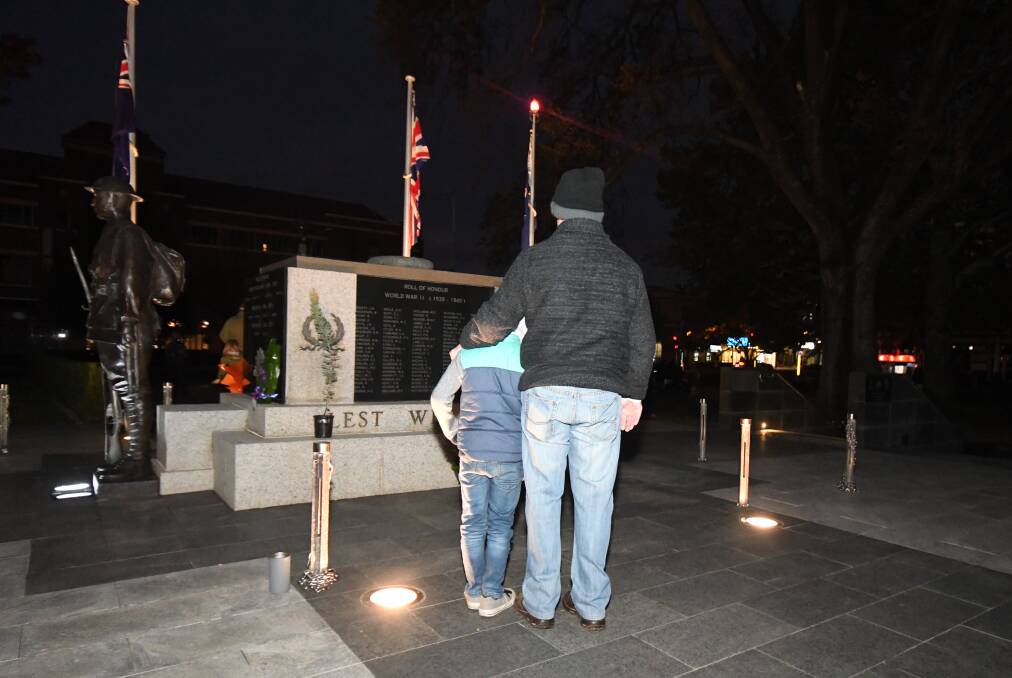 TOUCHING MOMENT: Lincoln Buesnel and Tony Wilson at the Cenotaph at Thursday morning's Dawn Service. Photo: CARLA FREEDMAN