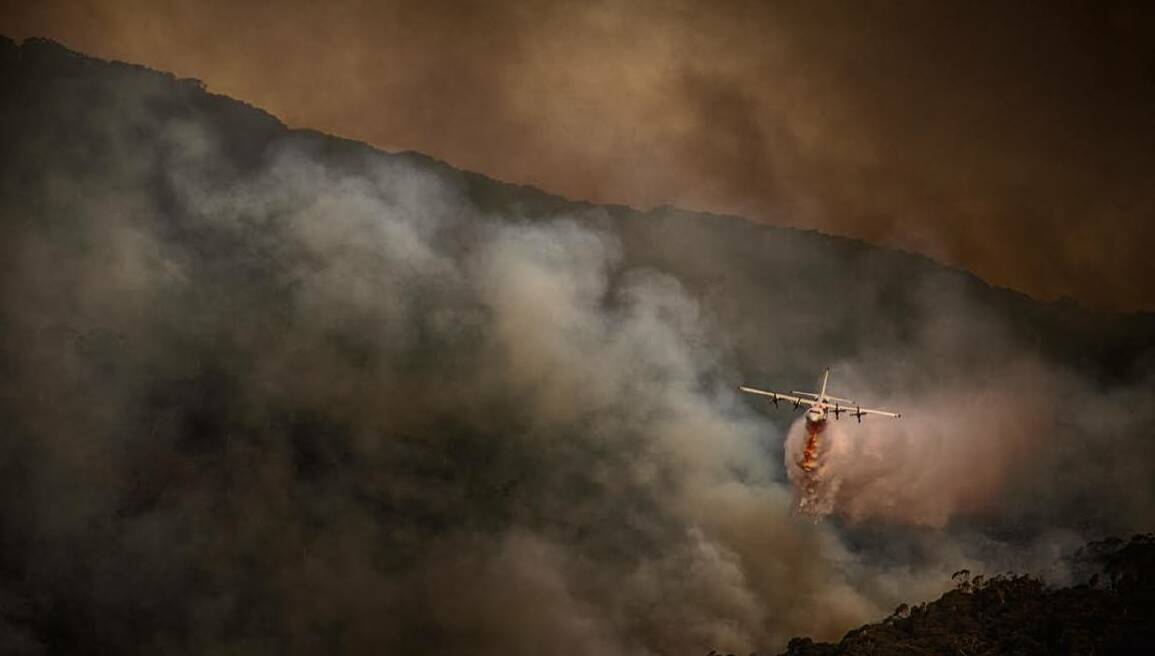 BOMBING: An aircraft drops a load of fire retardant during the effort to fight the fire on Mount Canobolas. Photo: SCOTT GILBANK 