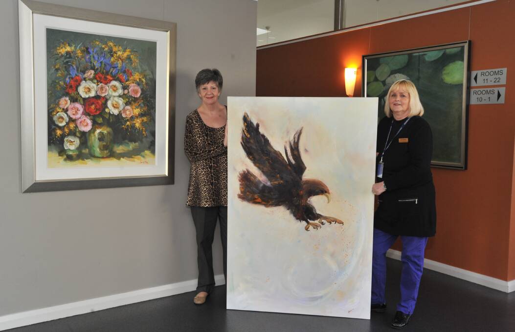 WORTH HANGING ON TO: Lita Mathews and Jan Savage with yet another donated piece for the Western Care Lodge's already impressive collection of artworks. Photo: JUDE KEOGH 0810jklodge3