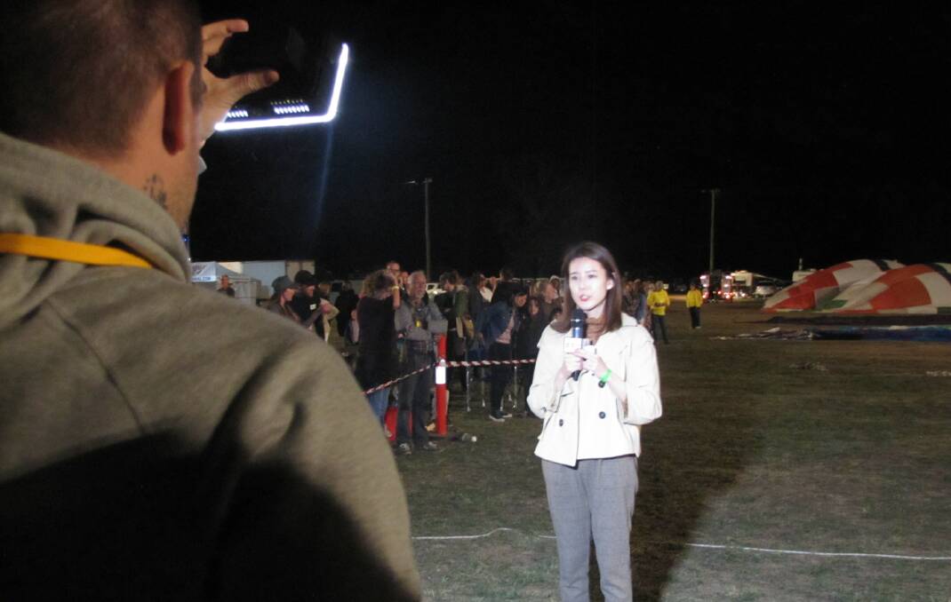 GOING LIVE: On-air talent from China’s Xinhua News Agency reporting live from Canowindra's Balloon Glow on the weekend. Photo: CABONNE COUNCIL