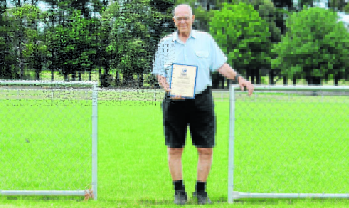 DESERVING: Bernie Stedman in 2015 with his Football NSW State Award at the field named after him. Photo: JUDE KEOGH