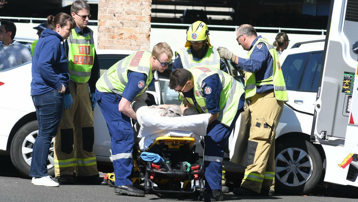 ASSISTANCE: Ambulance and fire workers remove the driver from her car after the accident in Sale Street on Thursday. Photo: JUDE KEOGH 0927jkcrash9