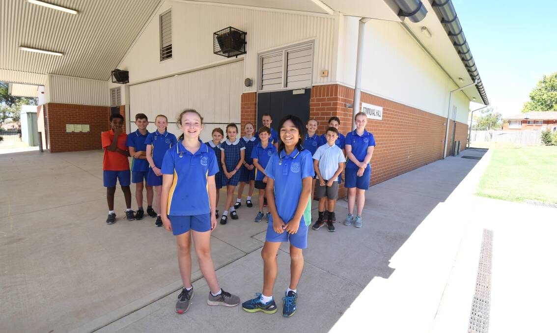 FRIDAY FETE: School captains Josie Fuller and Martin Mangsa with fellow students in front of the hall which is due for an upgrade. Photo: JUDE KEOGH