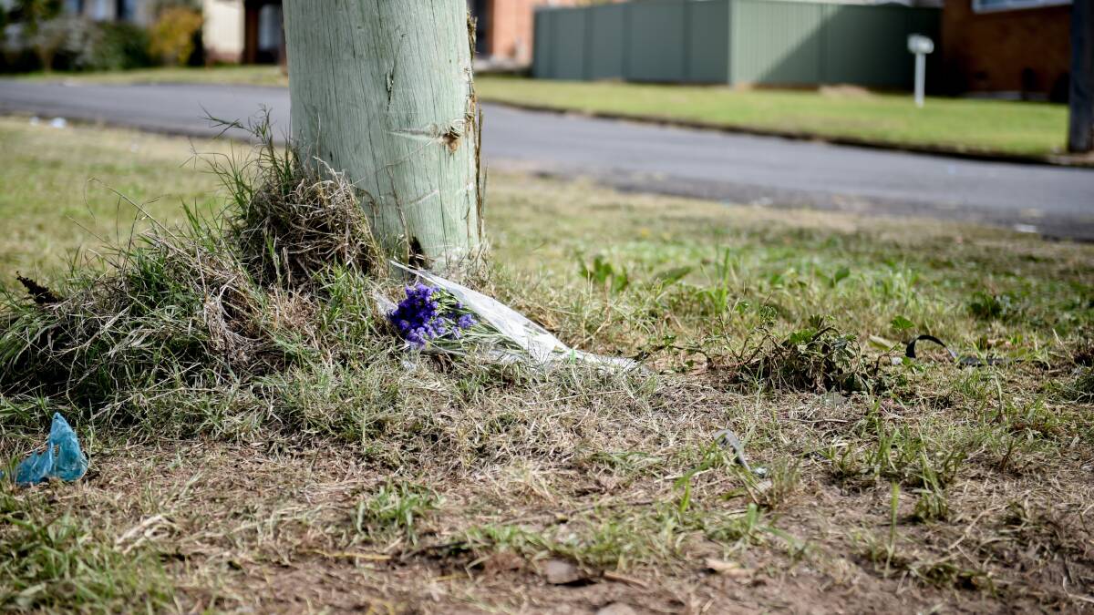 Flowers and skid marks at site of fatal car crash, investigations ongoing