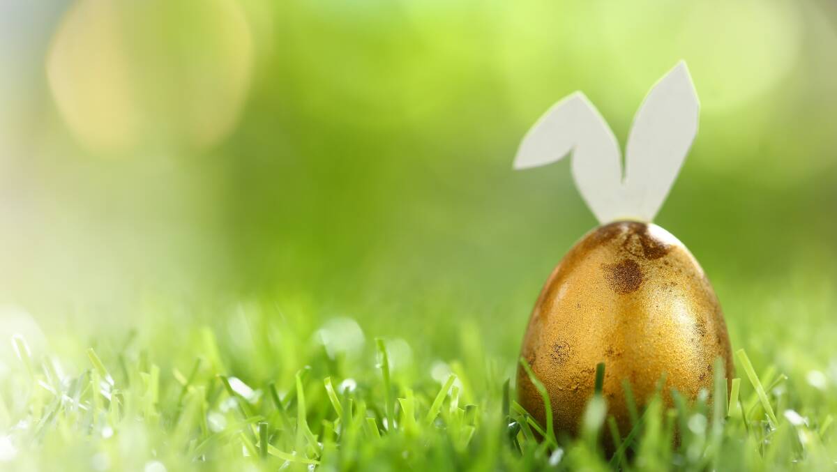 A gold Easter egg with bunny ears on grass. Picture is from Shutterstock
