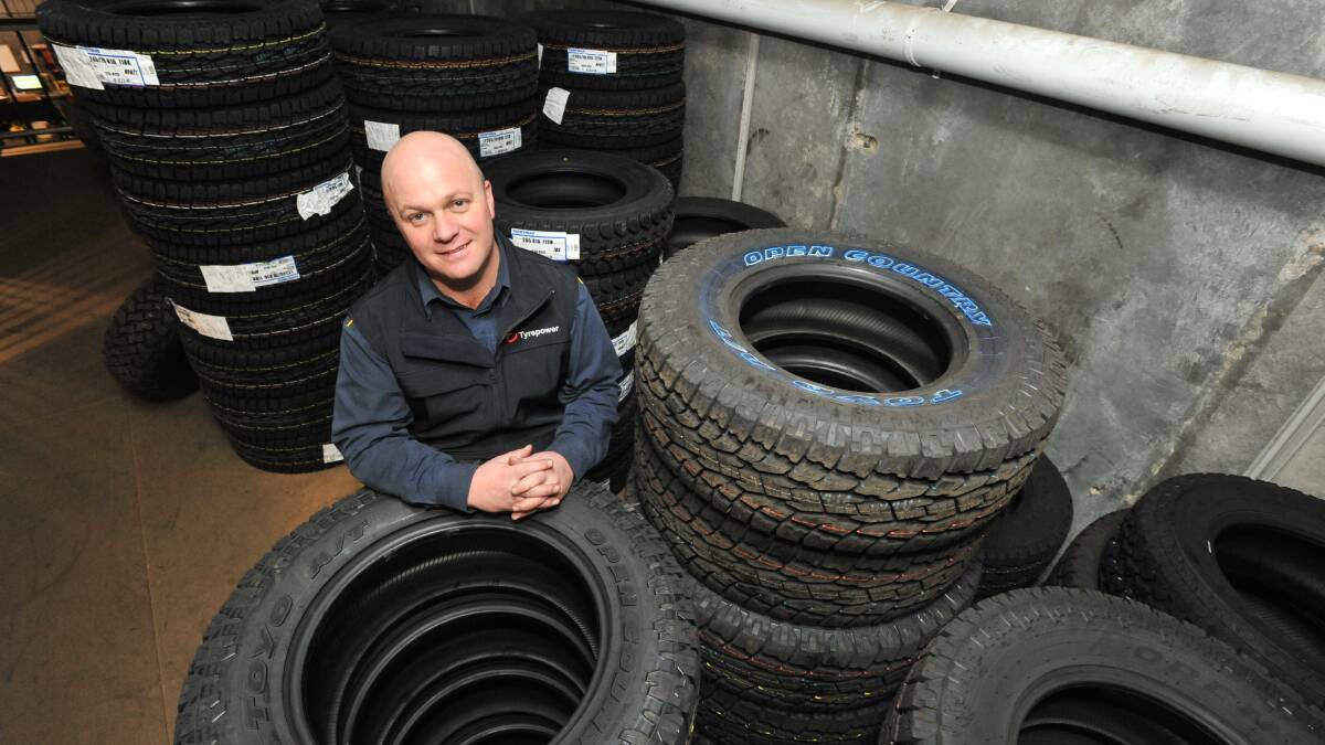BURNT RUBBER: Tyrepower Orange's Tim Allen among the store's used tyres. Photo: JUDE KEOGH 0703jktyre3