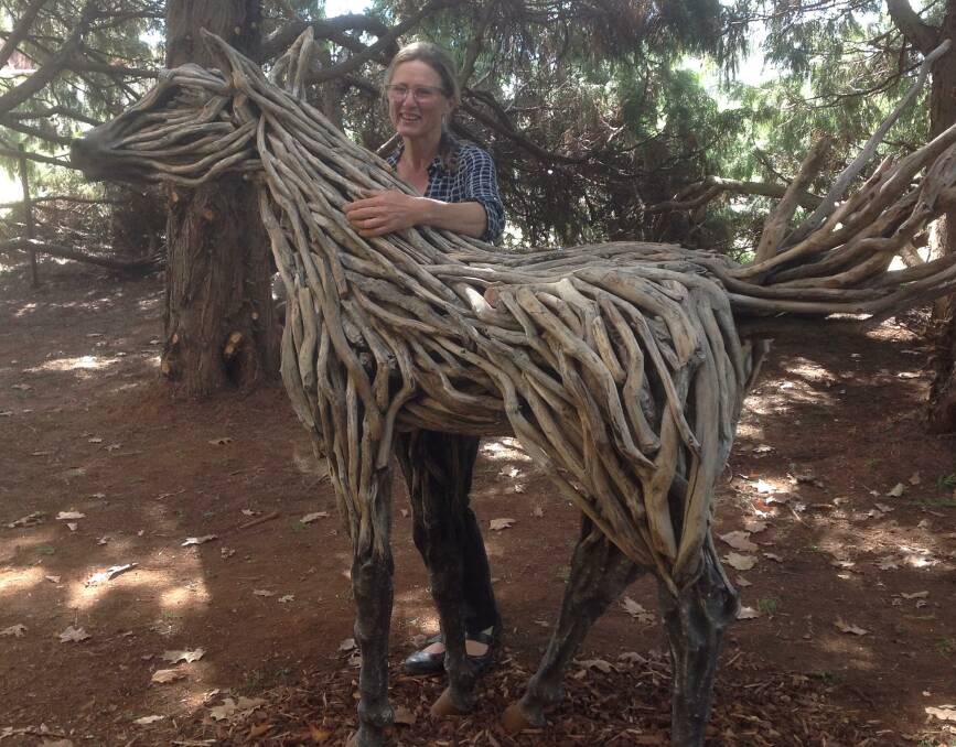 Vikki Holik-Blazley with her second prize sculpture in the people's choice, a timber horse. 