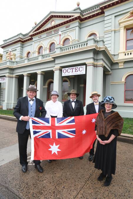 DRESSED TO IMPRESS: Mayor Reg Kidd, Trudy Mayfield,Scott Maunder, Sean Brady and Jan Richards with the red ensign - Australia's flag in 1918. Photo: JUDE KEOGH 1107jktownhall5