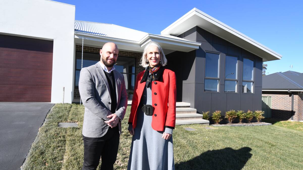 COLOUR TREND: Williams Machin agents Marty Lyden and Doone Grist in front of one of their listings in Japonica Place, which features dark grey cladding. Photo: JUDE KEOGH
