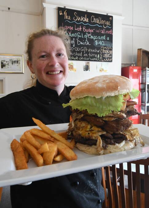 BRING IT ON: Mackie's Cafe's Melissa Fieldus with the Swole Challenge burger. Photo: JUDE KEOGH 0329jkburger1