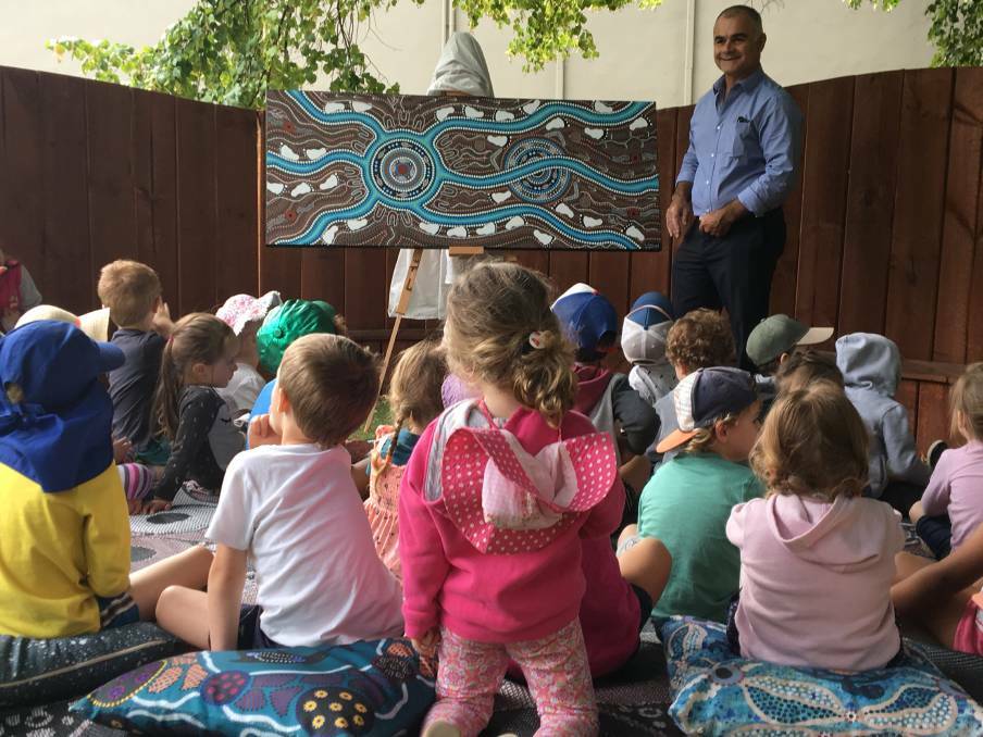 COLOURFUL ADDITION: Glenn Sutherland described his art to the Goodstart Early Learning children on Kite Street ahead of its donation to the centre.