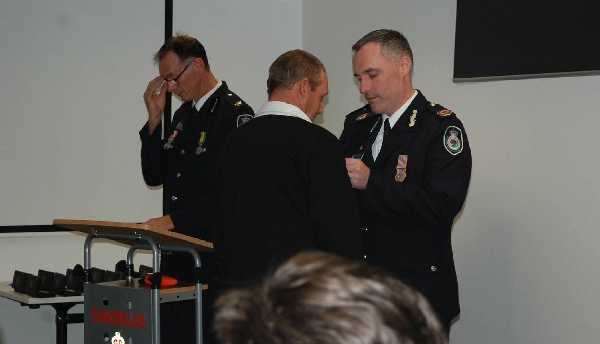 RECOGNITION: RFS assistant commissioner Jason Heffernan awards Michael Wright his medal for 26 years' service. Photo: SUPPLIED