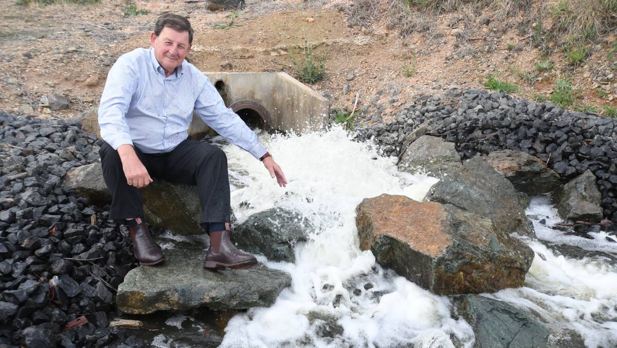 WET FINGERS: Mayor Reg Kidd enjoys the water flowing into Suma Park Dam from the Macquarie River. Photo: JUDE KEOGH