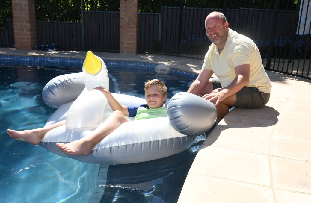 SAFE FUN: Mortimer and Jason Hamling enjoy the water during the Christmas break. Photo: JUDE KEOGH 1227jkpoolsafe1