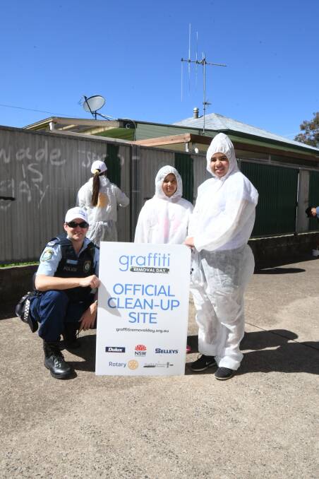 CLEAN-UP OPERATION: Central West Police District Senior Constable Granton Smith with volunteers Lily and Chloe Fields. Photo: CARLA FREEDMAN 1021cfgraffiti2