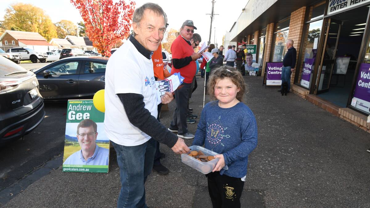 SUGAR HIT: The Australian Conservatives' Garry McMahon takes a biscuit from Alice Barnard, who has been keeping volunteers fed all week. Photo: JUDE KEOGH