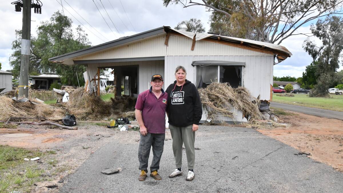 George and Sue Cross stand in front of the house that washed down the street towards Mavis and those trying to rescue her. Picture by Carla Freedman