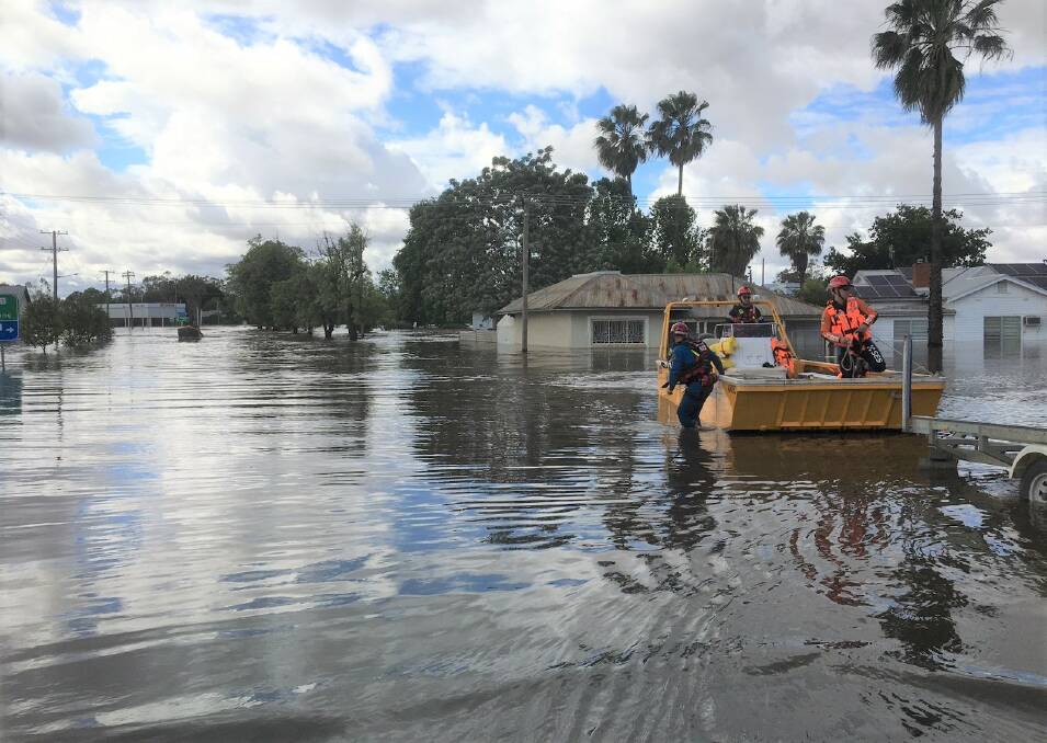 State Emergency Services ferrying emergency personnel and health workers through the flooded town centre during the second November flood peak. Picture by Jenny Kingham