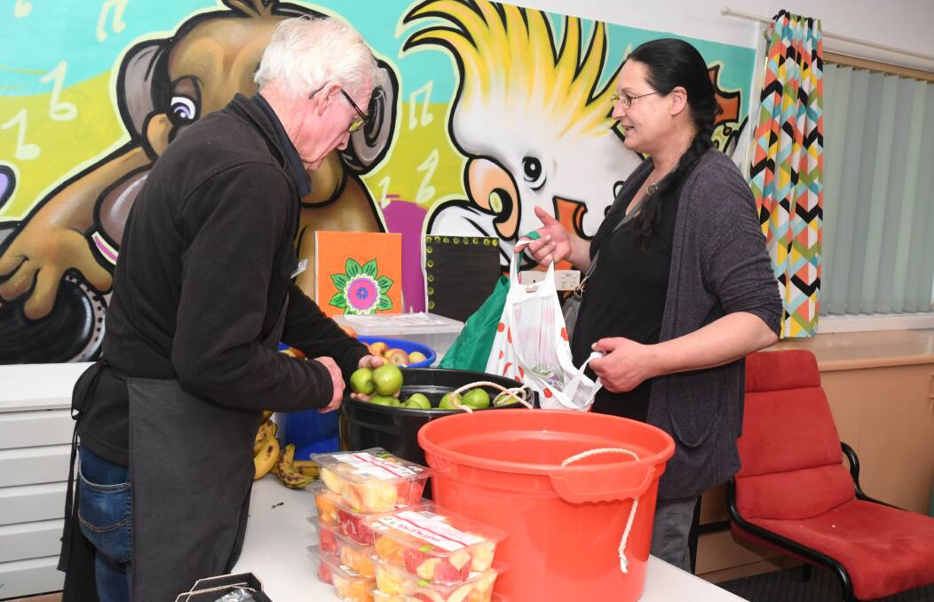 HELPING OUT: Roger Tarrant serves Lisa Kennedy at Foodcare Orange. Photo: JUDE KEOGH 1120jkfoodcare1